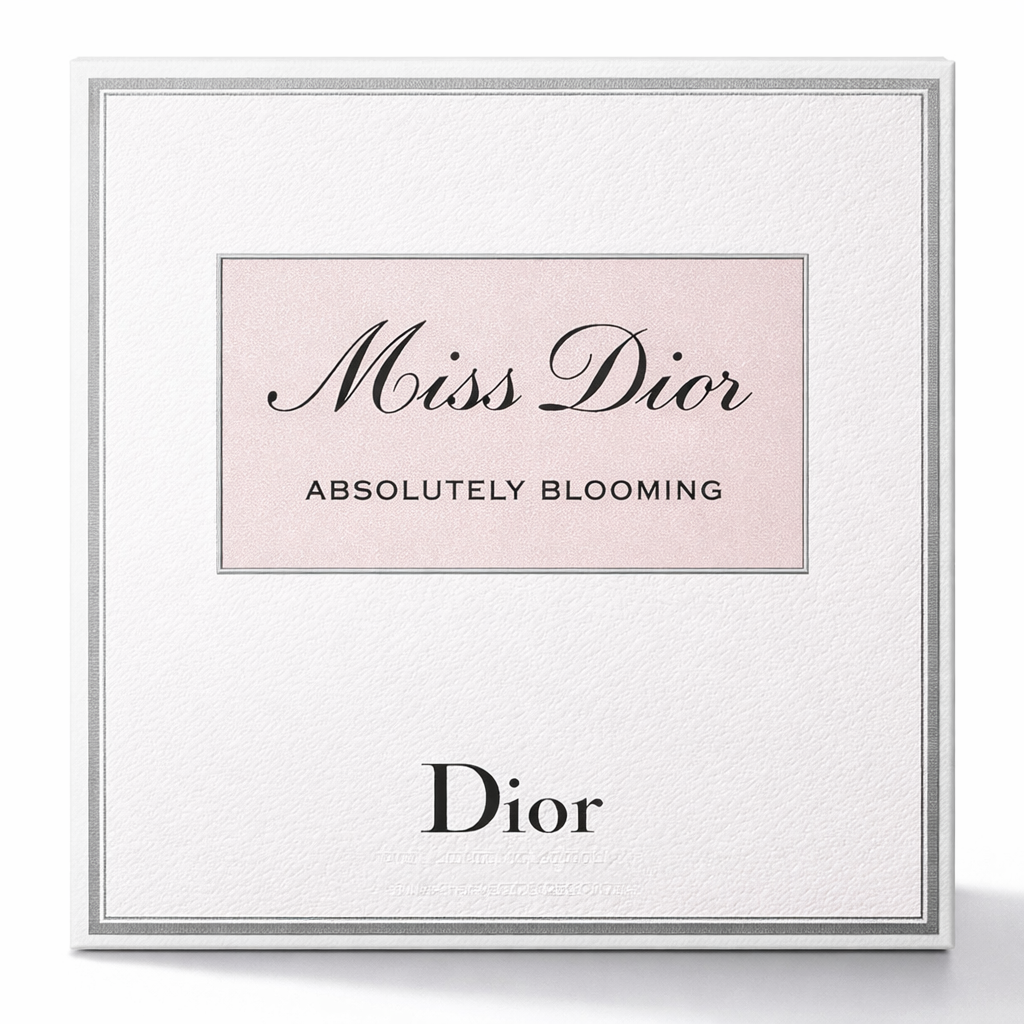 Framed Dior advertisement with 'Miss Dior Absolutely Blooming' text on a light pink background.